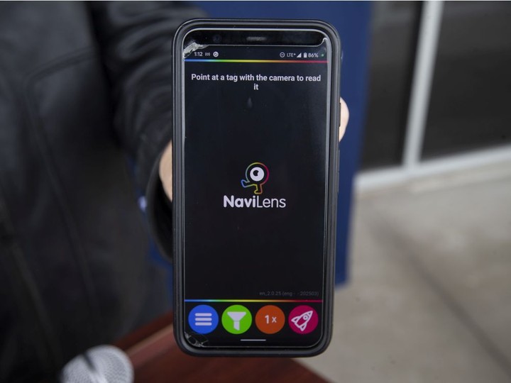  Essex Mayor Richard Meloche holds a smartphone with the NaviLens wayfinding system app, which was just launched to help visually impaired individuals navigate their way through Town of Essex facilities, on Thursday, March 24, 2022.