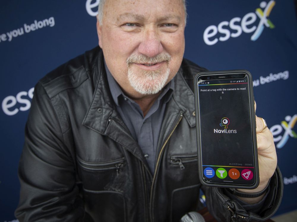 Essex mayor Richard Meloche holds a smartphone with the NaviLens wayfinding system app, which was just launched to help visually impaired individuals navigate their way through Town of Essex facilities, on Thursday, March 24, 2022.
