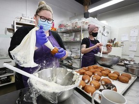 Pastry chefs Rachel Kuhn, left, and Brie Pilgrim prepare paczkis at the Sweet Revenge Bake Shop in Windsor on Tuesday, March 1, 2022.