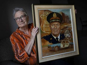 Shirley Ann Shuttleworth holds a portrait of her late father, John Shuttleworth, that was given to him on his retirement from the Windsor police force, on Tuesday, March 15, 2022. Shuttleworth died March 8, at the age of 98.