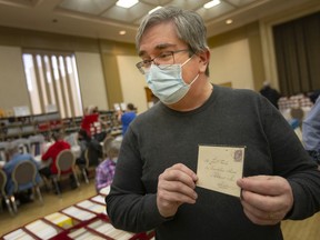 Bill Longley, a dealer and appraiser, holds an envelope that contained a letter sent to Queen Victoria's official painter three days after she died, while at the WINPEX Stamp Show at the Caboto Club, on Saturday, March 12, 2022.