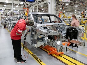 Stellantis assembly workers work on assembling the 2021 Jeep Grand Cherokee L at the Detroit Assembly Complex - Mack Plant in Detroit, Michigan, U.S., June 10, 2021.