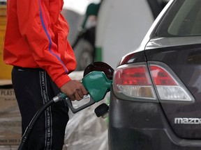FILE PHOTO: A person uses a petrol pump at a gas station as fuel prices surged in Manhattan, New York City, U.S., March 7, 2022.
