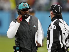 Head coach Brian Flores of the Dolphins talks with line judge Mike Dolce #123 during the fourth quarter against the Titans at Nissan Stadium in Nashville, Jan. 2, 2022.