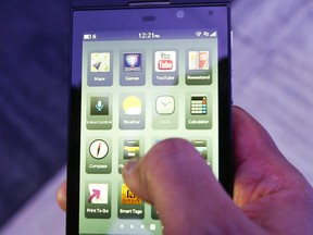 A BlackBerry PR employee demonstrates the new BlackBerry Z10 phone during the launch of the BlackBerry 10 platform at the Carlu in downtown Toronto on Jan. 30, 2013.