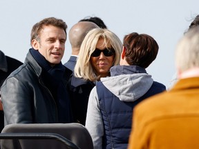 France's President and LREM party presidential candidate Emmanuel Macron and his wife Brigitte Macron meet people during a walk in the city where he voted for the first round of France's presidential election at a polling station in Le Touquet, northern France on April 10, 2022.
