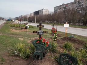 Graves of civilians killed during Ukraine-Russia conflict are seen next to apartment buildings in the southern port city of Mariupol, Ukraine April 10, 2022.