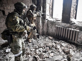 Two Russian soldiers patrol in the Mariupol drama theatre, bombed last March 16, in Mariupol on April 12, 2022.