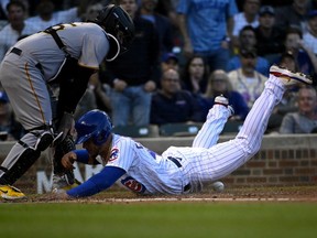 Chicago Cubs catcher Willson Contreras scores past Pittsburgh Pirates catcher Roberto Perez during the first inning at Wrigley Field.