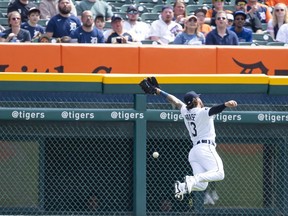 Detroit Tigers left fielder Eric Haase dives but cannot make a catch on a high fly ball from Colorado Rockies right fielder Charlie Blackmon  during the first inning at Comerica Park.