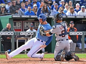 Detroit Tigers catcher Dustin Garneau tags out Kansas City Royals designated hitter Hunter Dozier at home plate during the second inning at Kauffman Stadium.