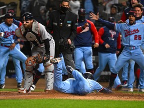Minnesota Twins third base Gio Urshela slides home for the game-winning run as teammates celebrate after a throwing error by Detroit Tigers catcher Eric Haase during the ninth inning at Target Field.