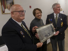 Barbara Porter, vice-president of the Amherstburg Freedom Museum, presents Morris Brausa (ret. col), left, and President of Royal Canadian Legion Branch 594, Tom Friesen, with a photo of the No. 2 Construction Battalion, on Tuesday, April 26, 2022.