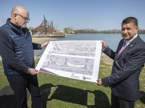 Mayor Drew Dilkens and Ward 7 Coun. Jeewen Gill, hold up a drawing of the proposed changes to Sand Point Beach, during a press event on Thursday, April 28, 2022.