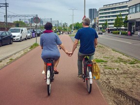 Mobility experts Melissa and Chris Bruntlett, of consulting firm Modacity, are shown cycling along a path in the Dutch city of Delft in 2019.