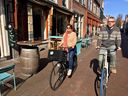 Mobility experts Melissa and Chris Bruntlett, of consulting firm Modacity, are shown cycling along a street in the Dutch city of Delft in 2019. 