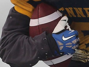 A Kennedy Collegiate Institute player clutches a football during a game in 2018.