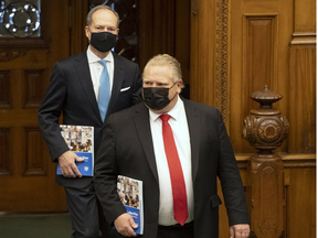 Ontario Finance Minister Peter Bethlenfalvy (back) arrives in the Ontario legislature in Toronto with Premier Doug Ford ( front) to deliver the provincial budget on March 24, 2021.