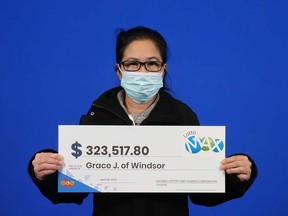 Grace Jao of Windsor holds her prize cheque for $323,500 that she won playing Lotto MAX in March 2022.