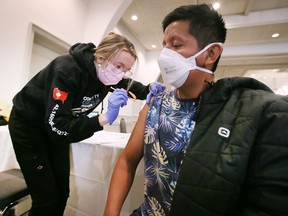 Gemma Fontanin, a fourth year nursing student and member of the Community Response Stabilization Team delivers a vaccine shot to Kendy Tavike, a worker from Guatemala at the Health and Information Fair for Migrant Workers event at the Roma Club in Leamington on Sunday, April 3, 2022.