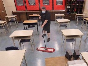 A custodian cleans a classroom at Kennedy Collegiate Institute in Windsor in this February 2021 file photo.D