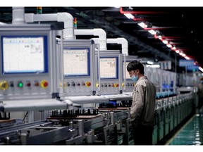 FILE PHOTO: An employee works on the production line of electric vehicle (EV) battery manufacturer Octillion in Hefei, Anhui province, China March 30, 2021.