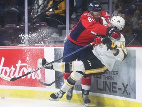 WINDSOR, ONTARIO. APRIL 21, 2022 - Matthew Maggio, left, of the Windsor Spitfires knocks Alexis Daviault of the Sarnia Sting off his feet on Thursday, April 21, 2022 at the WFCU Centre in Windsor.