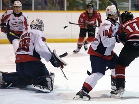 Windsor Spitfires' goalie Matt Onuska makes one of his 33 saves during Saturday's 6-3 win over the Owen Sound Attack while Daniil Sobolev boxes out Cedrick Guindon, who is looking for a rebound.