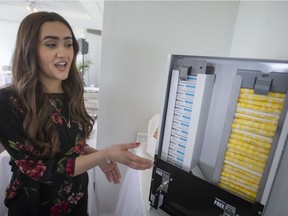 Jada Malott, owner of Period Product Partner, displays her coin-free pad and tampon dispensers during a press event at the Harbour House, on Wednesday, April 27, 2022.
