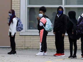 Students at a school in Toronto wear masks before entering the building in this September 2020 file photo.