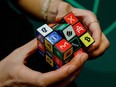 An attendee plays with a puzzle cube displaying logos of different cryptocurrencies and exchanges at the CryptoCompare Digital Asset Summit at Old Billingsgate in London, U.K., on Wednesday, March 30, 2022.