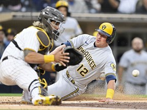 Hunter Renfroe of the Milwaukee Brewers scores ahead of the throw to Jorge Alfaro of the San Diego Padres during the second inning on May 23, 2022 at Petco Park in San Diego, California.