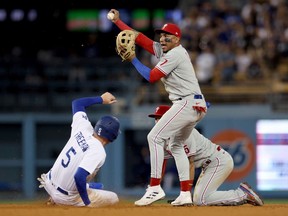 Johan Camargo of the Philadelphia Phillies reacts as he forces out Freddie Freeman #5 of the Los Angeles Dodgers in front of Bryson Stott to end the game with a 12-10 win, during the 10th inning at Dodger Stadium on May 13, 2022 in Los Angeles, California.