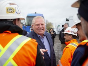 Ontario Premier Doug Ford greets workers at a construction site before speaking to the media in Brampton on Wednesday, May 4, 2022.