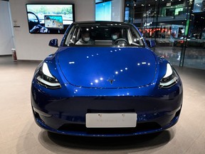 People try a Tesla Model Y car at a Tesla showroom at a shopping mall in Beijing on April 29, 2022.