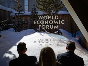 Participants check their messages on electronic devices during the World Economic Forum (WEF) annual meeting in Davos on Jan. 23, 2020.