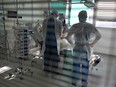 Health workers attend a patient infected with the COVID-19 at the intensive care unit for patients infected with the Covid-19 of the Timone hospital, in Marseille, southern France on Jan. 5, 2022.
