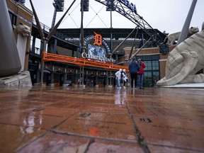 Fans walk out of the stadium after the game between the Detroit Tigers and the Colorado Rockies was postponed due to rain at Comerica Park.
