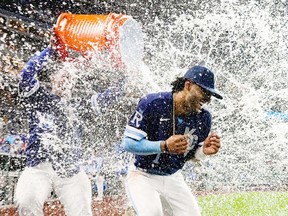 Kansas City Royals designated hitter MJ Melendez is doused with water by Kansas City Royals catcher Salvador Perez after defeating the St. Louis Cardinals at Kauffman Stadium.