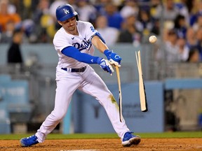Los Angeles Dodgers shortstop Trea Turner breaks his bat as he hits a single in the fourth inning against the Philadelphia Phillies at Dodger Stadium.