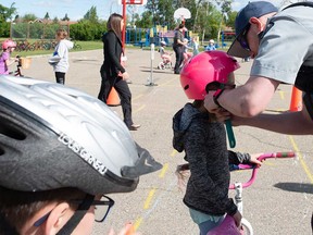 A child's bicycle helmet is adjusted at a bike rodeo in this 2019 file photo.