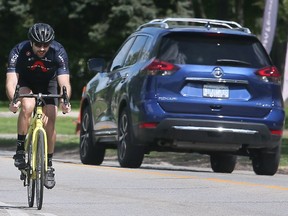A cyclist travels along Riverside Drive East in Windsor on Tuesday, May 17, 2022.