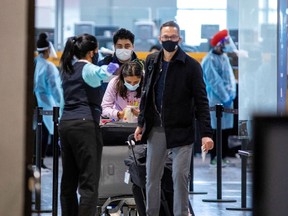 FILE PHOTO: Passengers wait to be tested after they arrive at Toronto's Pearson airport after mandatory coronavirus disease (COVID-19) testing took effect for international arrivals in Mississauga, Ontario, Canada February 15, 2021.