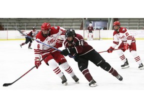 Leamington Flyers' Ryan Clark (6) is checked by Chatham Maroons' Cameron Symons (16) at Chatham Memorial Arena. Mark Malone/Chatham Daily News/Postmedia Network