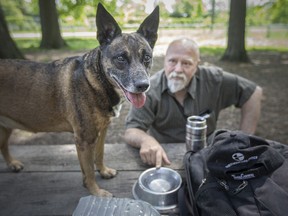 Isidore Bombardier sits with one of his three dogs, Qeeva, at the Optimist Park Dog Park, on Tuesday, May 24, 2022.