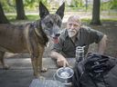 Isidore Bombardier sits with one of his three dogs, Qeeva, at the Optimist Park Dog Park on Tuesday, May 24, 2022.