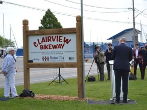 Windsor Mayor Drew Dilkens unveils new signage to the Clairview Bikeway Trail, connecting the Ganatchio Trail on the east and Wyandotte Street East on the west, Wednesday, May 25, 2022, while Coun. Jo-Anne Gignac, left, looks on.