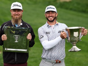 Caddie Joe Greiner, left, and Max Homa hold the Championship Trophies after winning the Wells Fargo Championship golf tournament in Potomac, Maryland, May 8, 2022.