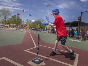 Alex Robitaille, 25, gets the first hit at the Inaugural Miracle League Ballgame during the grand opening of the Farrow Riverside Miracle Park, on Saturday, May 14, 2022.