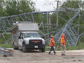 Hydro One works on some damaged and collapsed towers near Hunt Club Road in Ottawa on Tuesday. Several towers were toppled during last Saturday's storm.